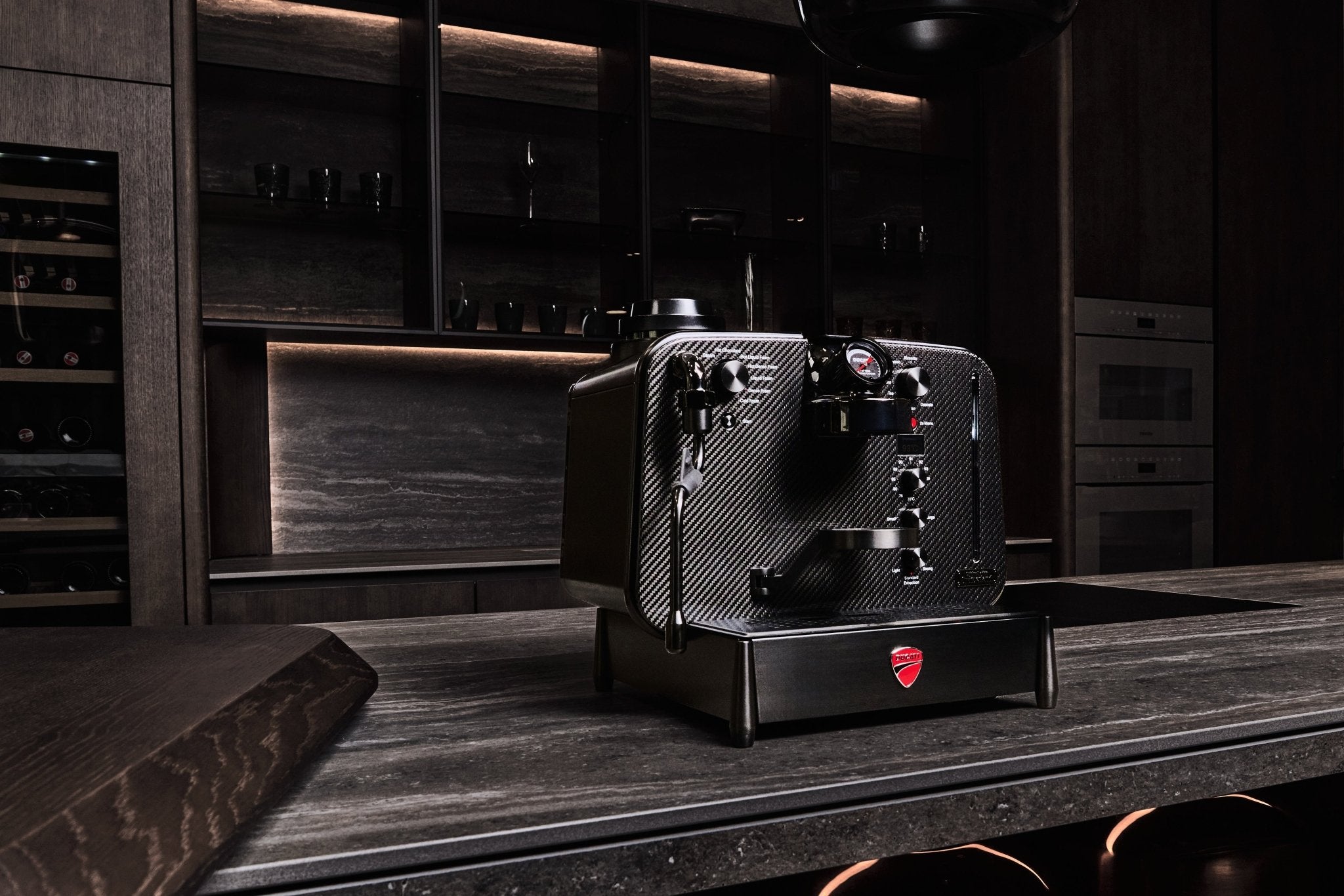 Barista M3 1926 Limited Edition i et mørkt luksuskøkken med vinkøleskab i baggrunden